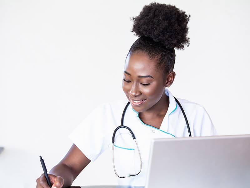 A young african american woman working in a doctor's office managing incoming referrals.