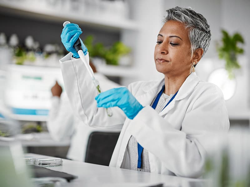 A female lab technician engaged in research. The results will be integrated with the EHR.