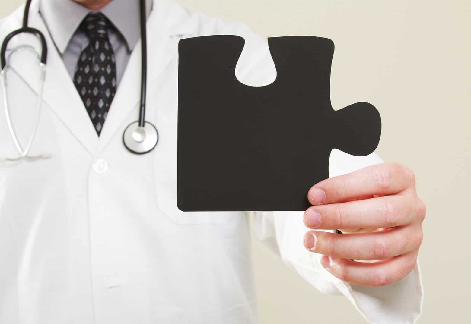 A physician holding a missing piece of a puzzle representing a care gap.