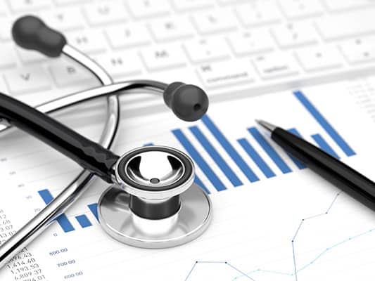 A stethoscope and pen sitting on top of a report with a bar graph, representing data from EHR integration.