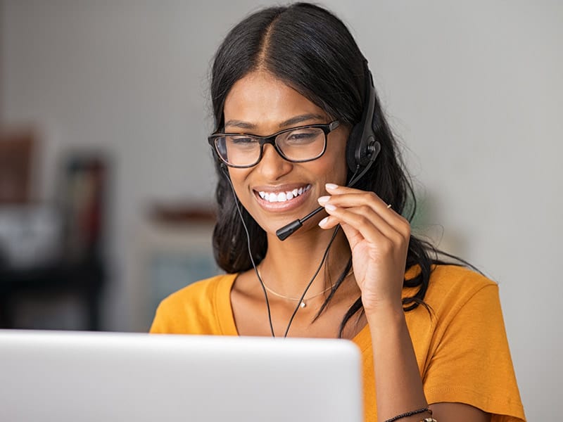 Happy woman working in a call center as a clinical care manager.