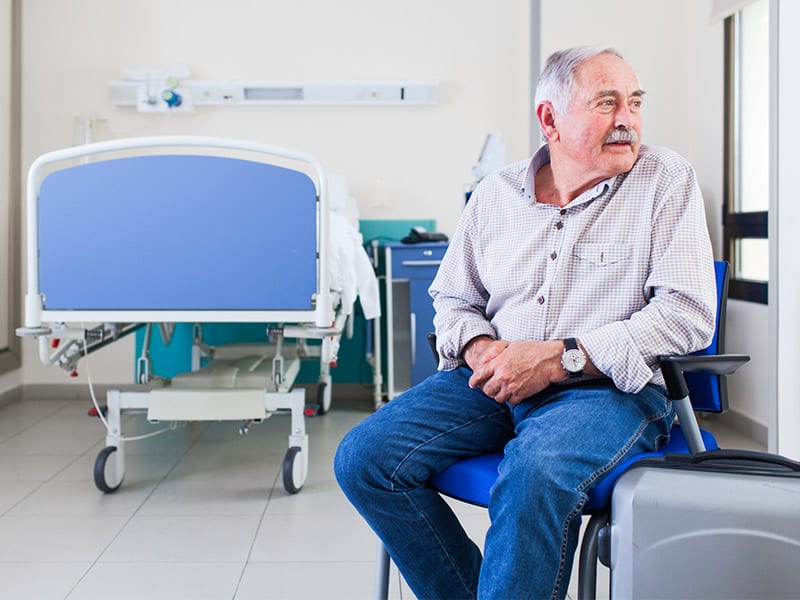 A-man-sitting-in-a-chair-in-a-hospital-room-waiting-to-be-formally-discharged-from-the-hospital