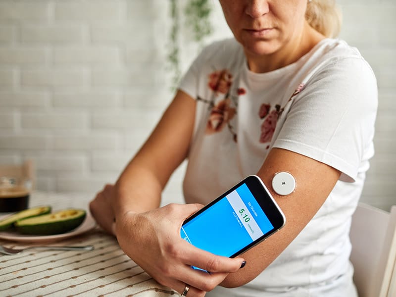 A-woman-checking-her-glucose-with-a-remote-patient-monitoring-application.