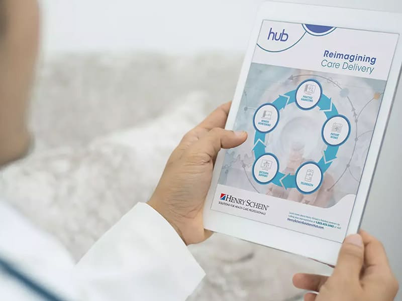 A-physician-looking-at-the-Henry-Schein-Solution-Hub-brochure-on-an-electronic-tablet.