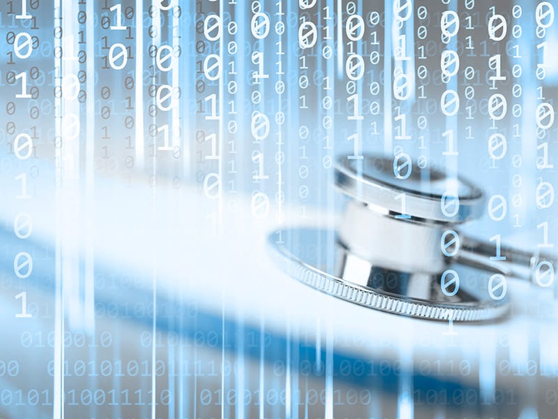 Healthcare interoperability concept with a stethoscope on a laptop and binary code.